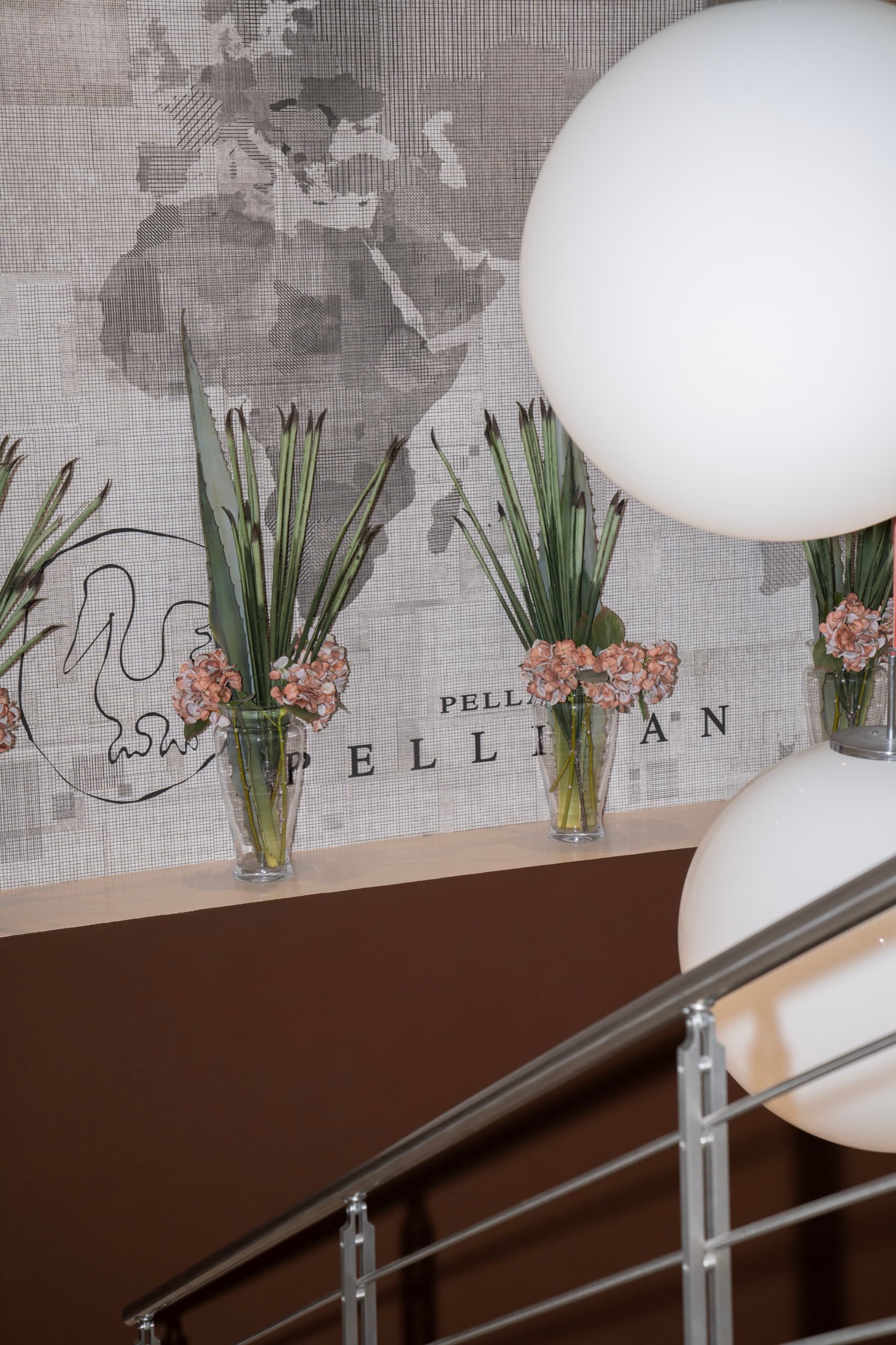 Lo showroom Pellican — la parete con il logo e le composizioni floreali